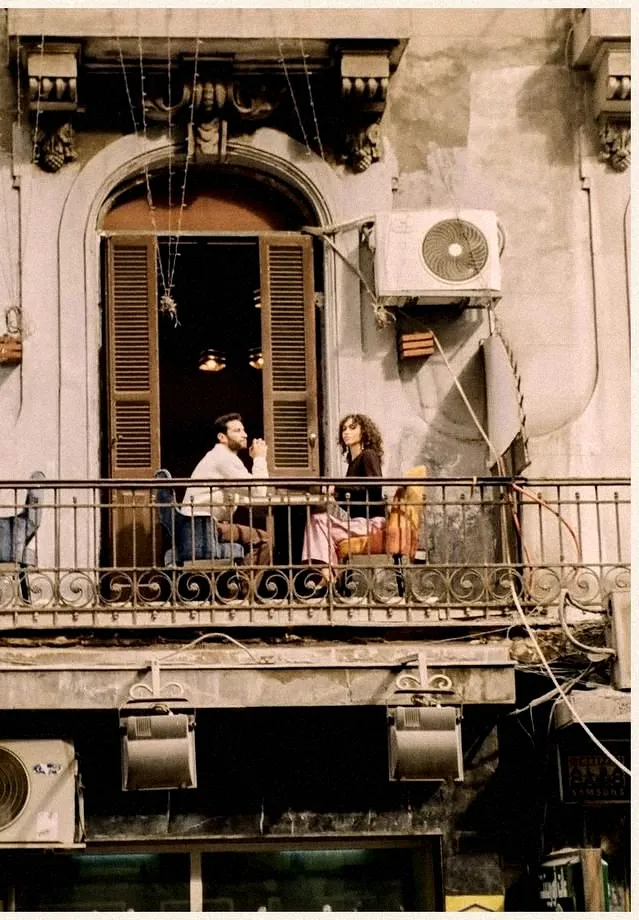 Two people talking on a downtown Cairo balcony