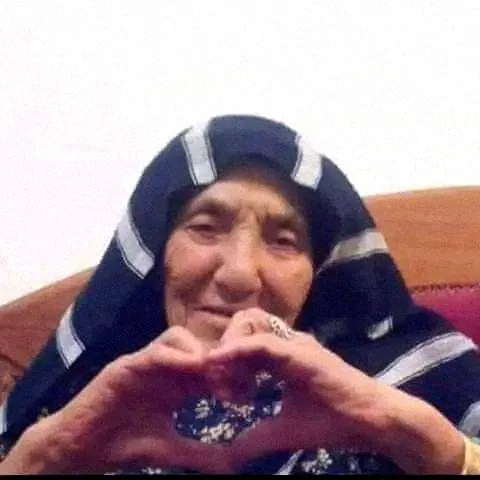 An Egyptian grandmother making a heart with her hands