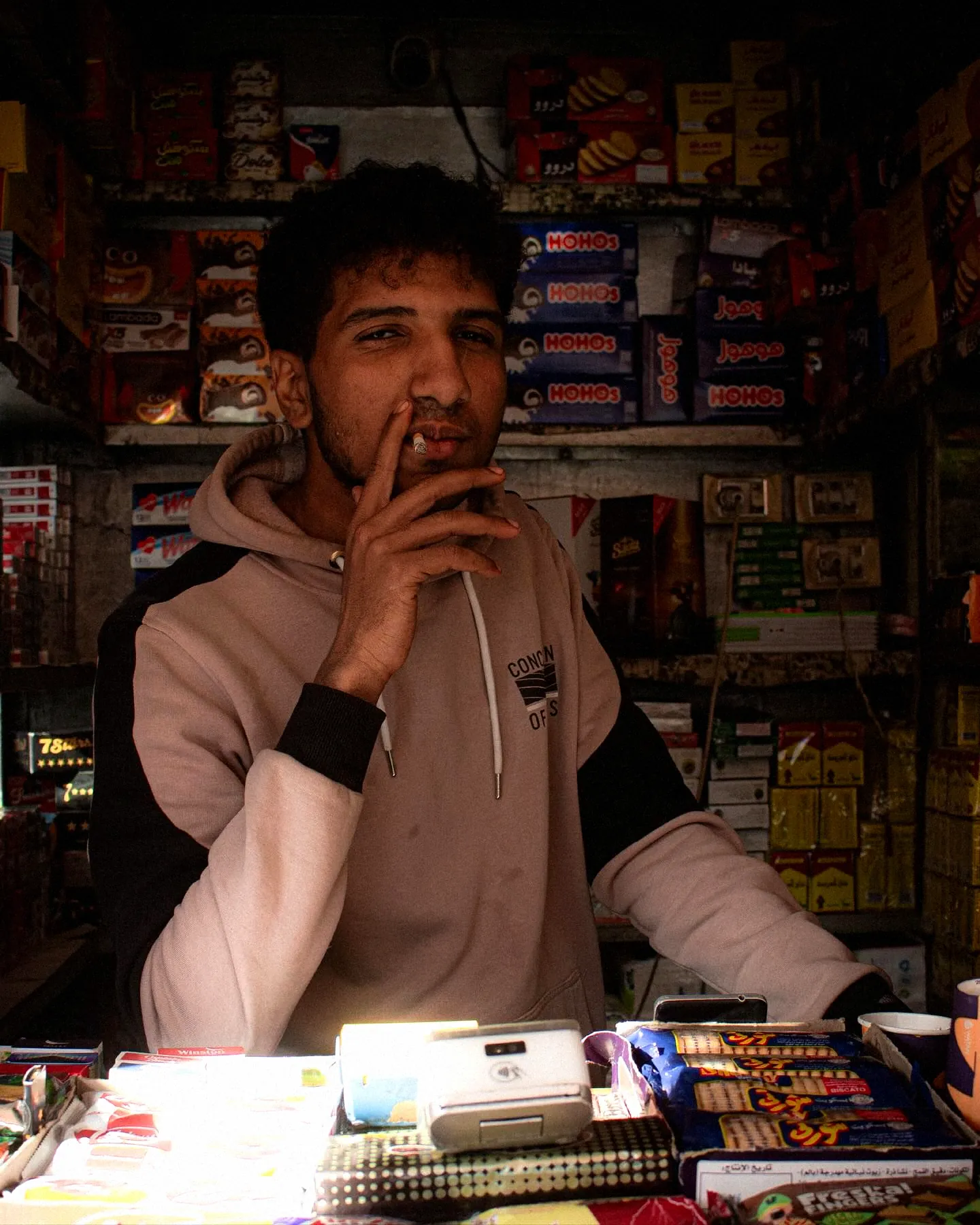 A young man inside his Cairo kiosk, surrounded by stock